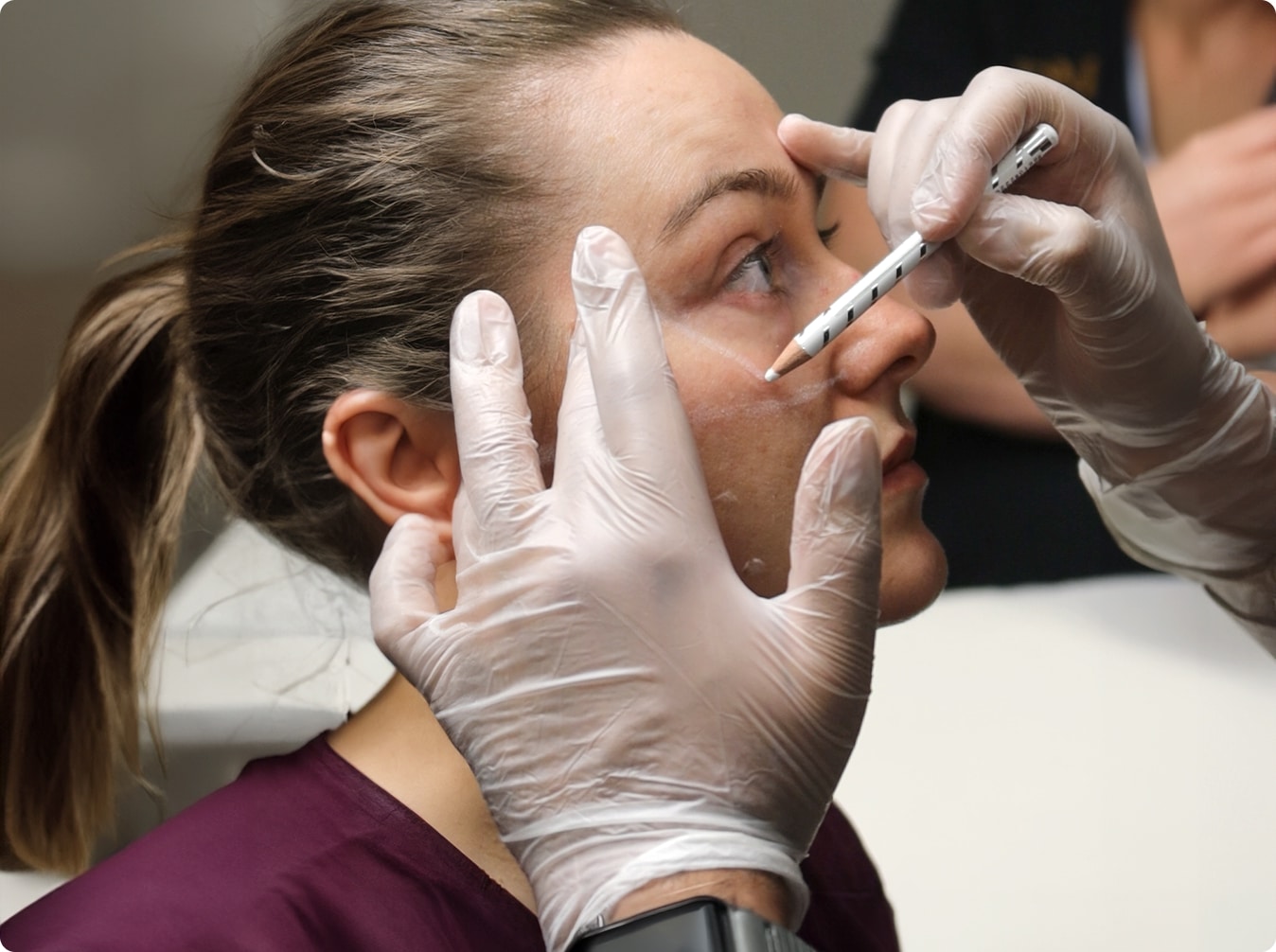 Trainer marking facial landmarks before injecting